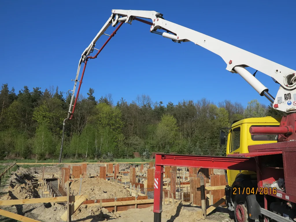 Wylewanie ław fundamentowych, w tle pompa do betonu 