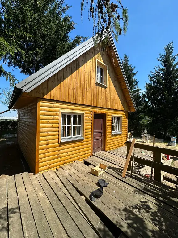 Odnowiony domek drewniany z nową elewacją – widok frontowy po realizacji.