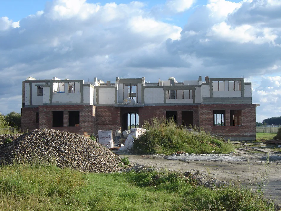 Budowa domu w stanie surowym, wykonane mury parteru i strop parteru. Murowane ściany piętra