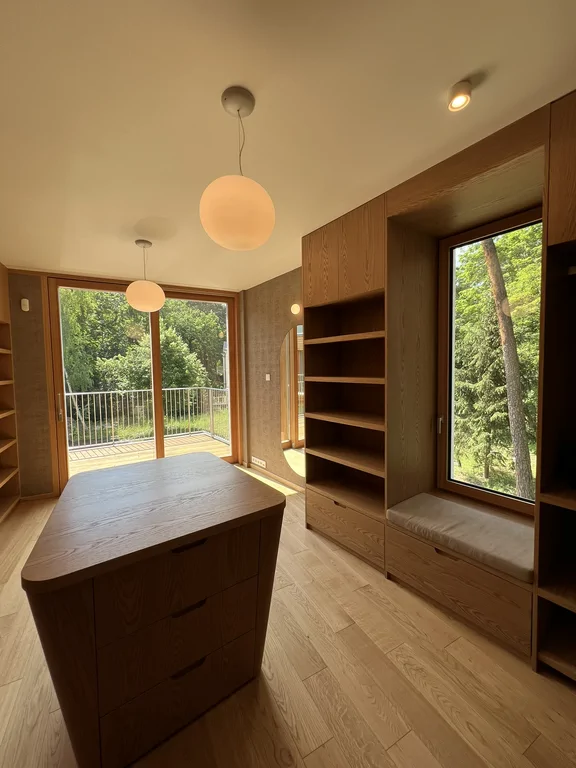 Garderoba z wyspą, siedziskiem przy oknie i widokiem na balkon