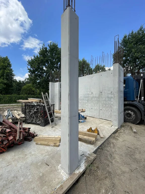 Słup i ściany z betonu architektonicznego po rozszalowaniu – widoczne kotwy, zbrojenie pod kolejny etap