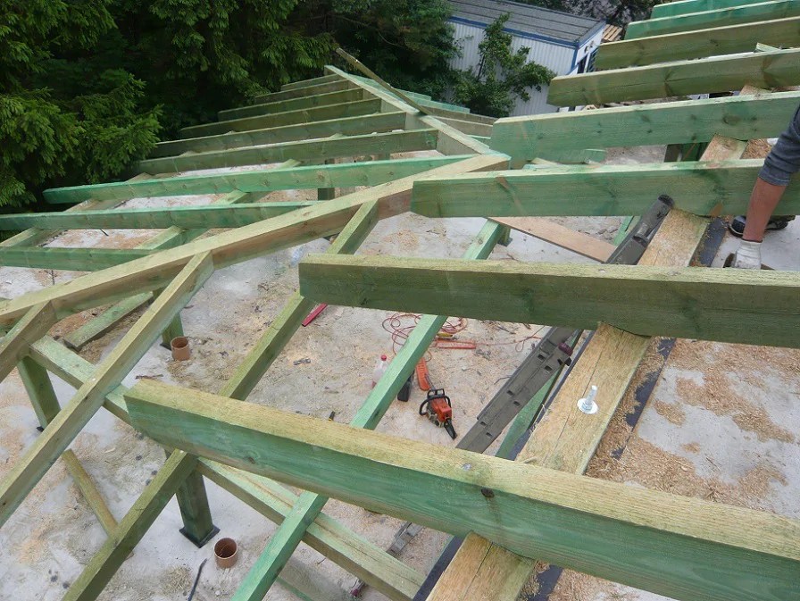 Montaż więźby dachowej – impregnowane elementy drewniane w trakcie prac ciesielskich