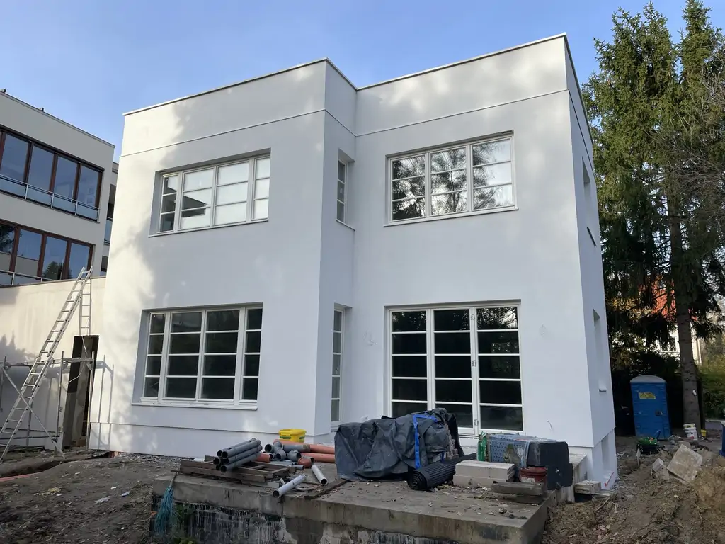 Budynek po kompleksowym remoncie – nowa biała elewacja w stanie deweloperskim.