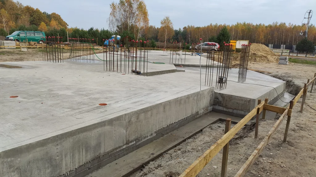 Krawędź płyty i podniesiony fragment fundamentu – przygotowane zbrojenie pod kolejne elementy konstrukcji.