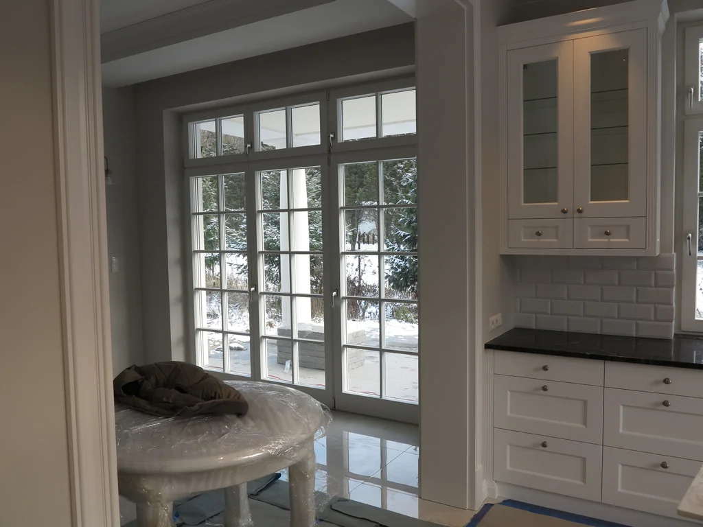 sufit podwieszany z jasnym oświetleniem, jasne meble, białą stolarka okienna 