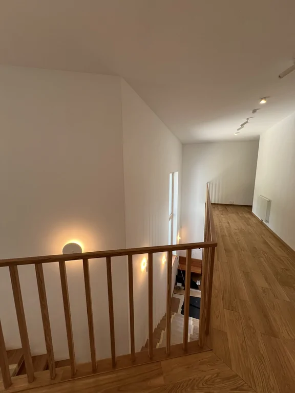 Antresola z drewnianą balustradą i widokiem na klatkę schodową