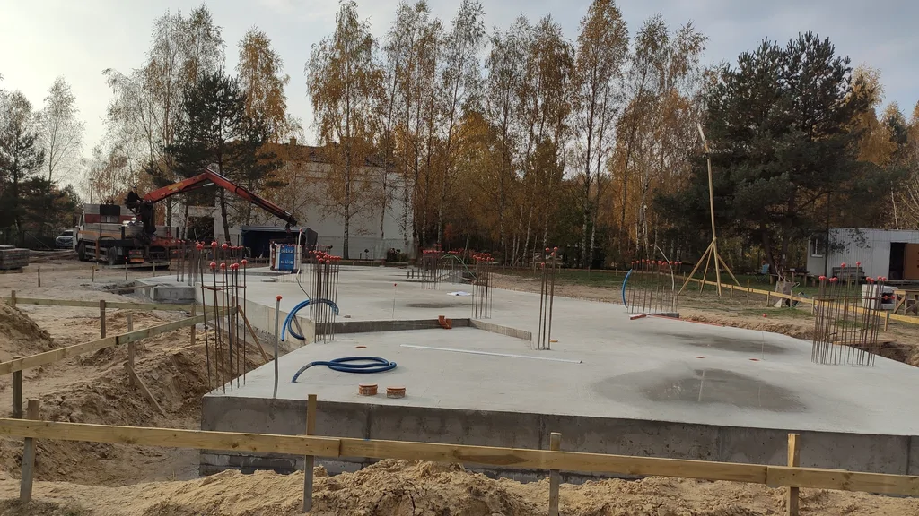 Płyta fundamentowa po związaniu betonu – wystające zbrojenie pod słupy/ściany oraz przepusty instalacyjne.