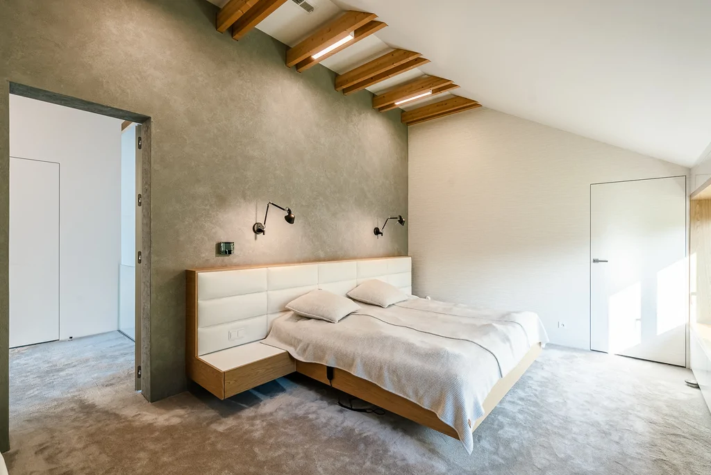 Sypialnia duże łóżko, wykładzina na podłodze, na ścianie tapeta 