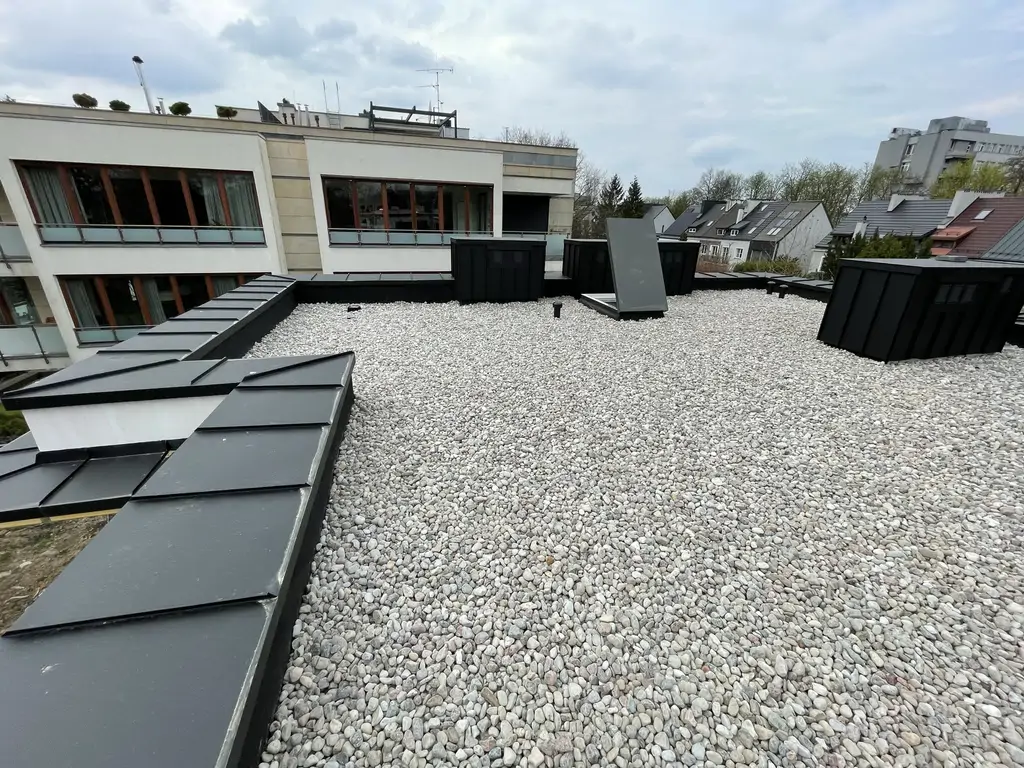 Dach płaski po realizacji prac remontowych – warstwa żwirowa i obróbki blacharskie.