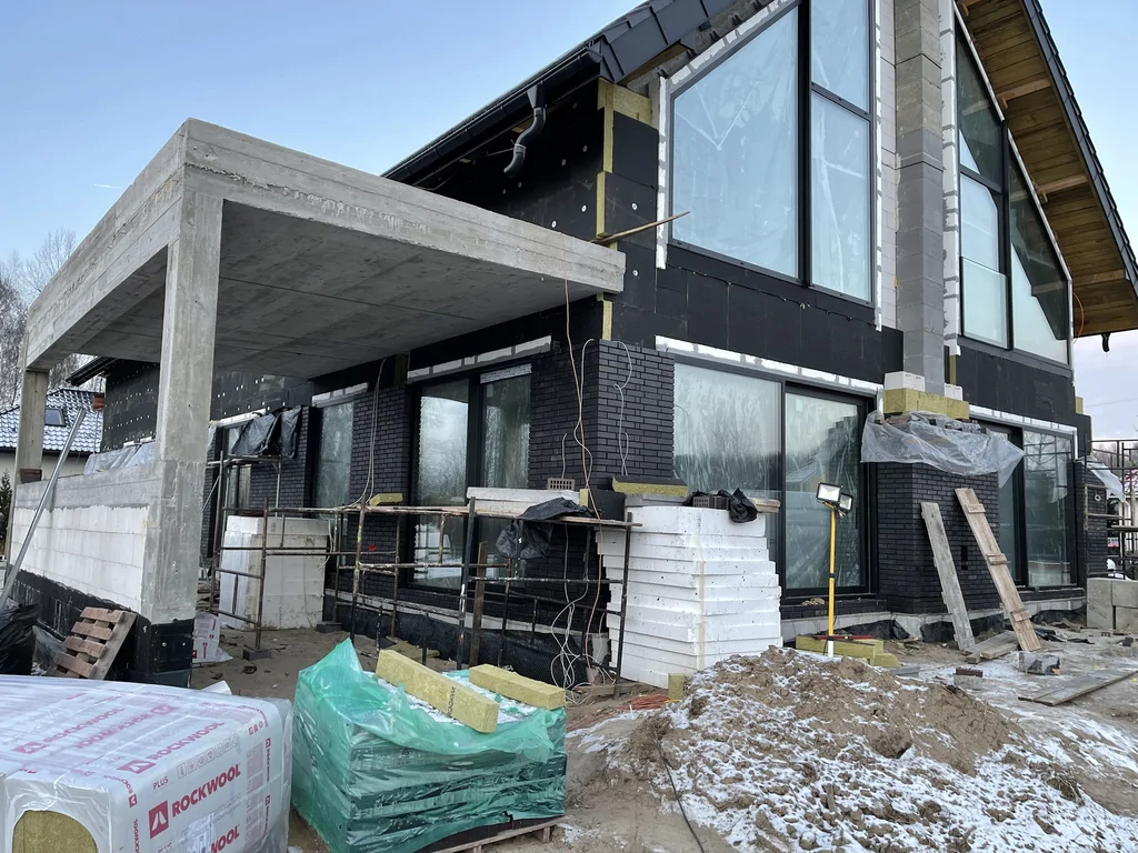 Elewacja w trakcie prac – ocieplenie i przygotowanie pod warstwy wykończeniowe przy dużych przeszkleniach